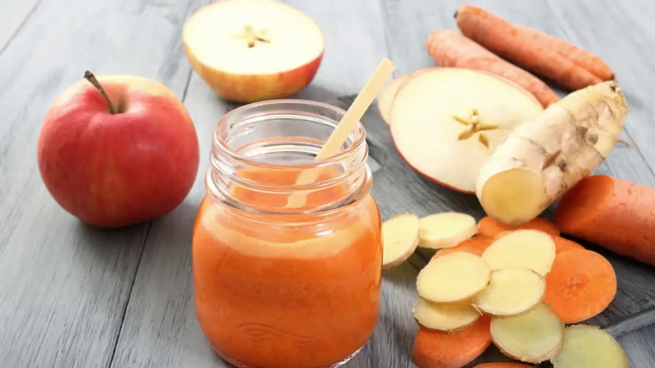 5 Irresistible Reasons Apple Carrot Juice Belongs in Your Product Line 1 A refreshing glass of apple carrot juice with slices of apple and carrot beside it.
